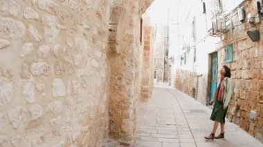 Şehirde telefonu olan bir kız. seyahat ve macera. Kız turist eski şehrin caddesinde yürüyor ve telefonla manzaranın fotoğrafını çekiyor.. 