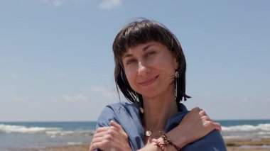 Havluya sarılmış, kumsalda eğlenen genç bir kadın. Havlu giymiş bir kız. Sahilde dinlen..