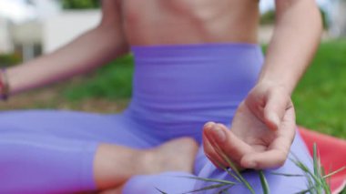 Parkta meditasyon yapan güzel bir genç kadın. Kavram. Parkta yoga yapan zeki genç bir kadın. Güneşli bir yaz gününde çimlerin üzerinde meditasyon yapan bir kadın..