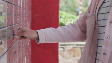 Bir kadın posta kutusunu açar ve içine bakar. Kızın biri posta kutusundan mektupları alıyor. Postanın alıcısı.