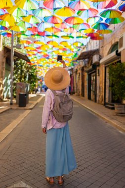 Kadın gezginlerin, tarihi şemsiye şehrinde telefonuyla şehir simgelerinin fotoğraflarını çekerken arka plan görüntüsü. İçerik yaratan kız.
