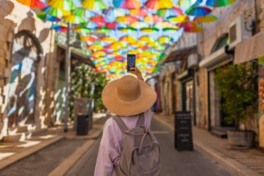 Kadın gezginlerin, tarihi şemsiye şehrinde telefonuyla şehir simgelerinin fotoğraflarını çekerken arka plan görüntüsü. İçerik yaratan kız.