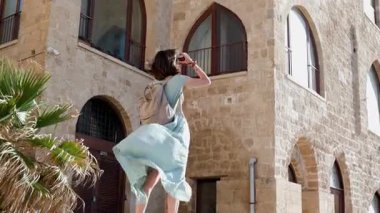 Kameralı kadın fotoğrafçı dışarıda çekim yapıyor. Genç bayan fotoğrafçı objektife nişan alıyor ve çekim sürecinin tadını çıkarıyor. Arap ülkelerine gitmek. seyahat ve tatil. 