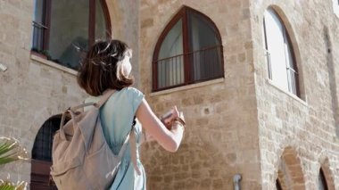 Kamerayla gezen ve simgelerin fotoğraflarını çeken bir kadın fotoğrafçı. Genç bayan fotoğrafçı çekim sürecinin tadını çıkarıyor. seyahat ve içerik oluşturma. jaffa. İsrail..