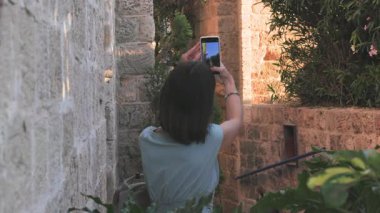 Açık havada yürüyorum. Kadın gezgin, tarihi bir şehirde telefonuyla tarihi işaretlerin fotoğraflarını çekiyor. Kız içerik yaratır. Seyahat ve tatil.