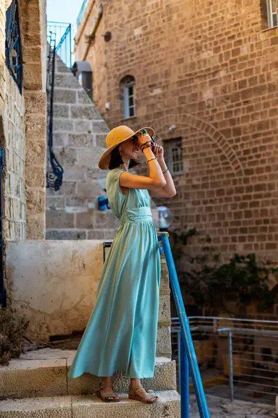 Şehirde fotoğraf çeken bir kadın fotoğrafçı. Genç bayan fotoğrafçı objektife nişan alıyor ve çekim sürecinin tadını çıkarıyor. seyahat ve içerik yaratmak. seyahat ve tatil.