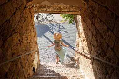 Açık havada yürüyorum. Neşeli gülümseyen stil sahibi kadın turist. Eski şehrin sokaklarında yürüyen bir gezgin. Seyahat ve tatil.