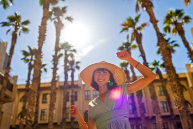 Kız tatilden ve şehirde gezmekten zevk alıyor. Eski Jaffa şehrinde güzel caddelerde yürüyen elbiseli genç bir kadın. İsrail. seyahat ve macera.