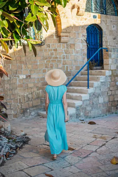 Büyüleyici görünümlü genç bir kadın eski Jaffa şehrinde güzel bir cadde boyunca yürüyor. İsrail. Seyahat ve macera.