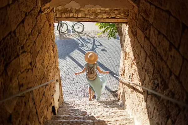 Açık havada yürüyorum. Neşeli gülümseyen stil sahibi kadın turist. Eski şehrin sokaklarında yürüyen bir gezgin. Seyahat ve tatil.