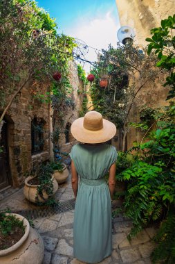 Açık havada yürüyorum. Neşeli gülümseyen stil sahibi kadın turist. Eski şehrin sokaklarında yürüyen bir gezgin. Seyahat ve tatil.