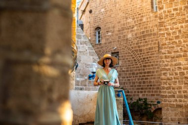 Şehirde fotoğraf çeken bir kadın fotoğrafçı. Genç bayan fotoğrafçı objektife nişan alıyor ve çekim sürecinin tadını çıkarıyor. seyahat ve içerik yaratmak. seyahat ve tatil.