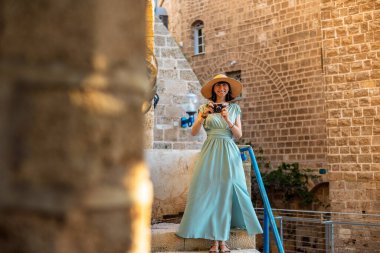 Şehirde fotoğraf çeken bir kadın fotoğrafçı. Genç bayan fotoğrafçı objektife nişan alıyor ve çekim sürecinin tadını çıkarıyor. seyahat ve içerik yaratmak. seyahat ve tatil.