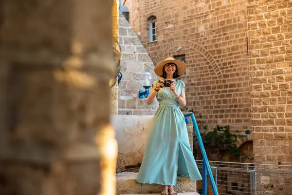 Şehirde fotoğraf çeken bir kadın fotoğrafçı. Genç bayan fotoğrafçı objektife nişan alıyor ve çekim sürecinin tadını çıkarıyor. seyahat ve içerik yaratmak. seyahat ve tatil.