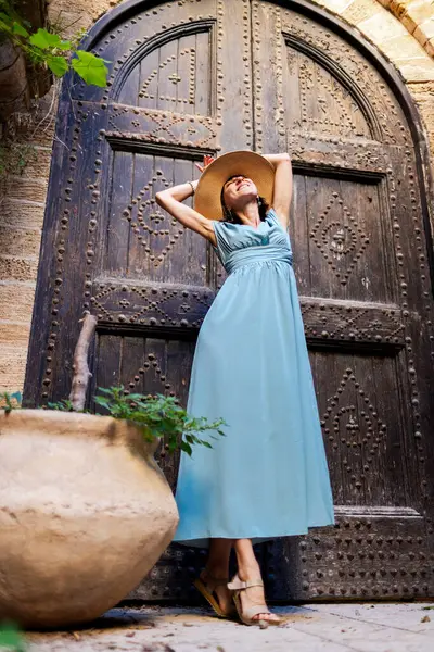 Açık havada yürüyorum. Neşeli gülümseyen stil sahibi kadın turist. Eski şehrin sokaklarında yürüyen bir gezgin. Seyahat ve tatil.