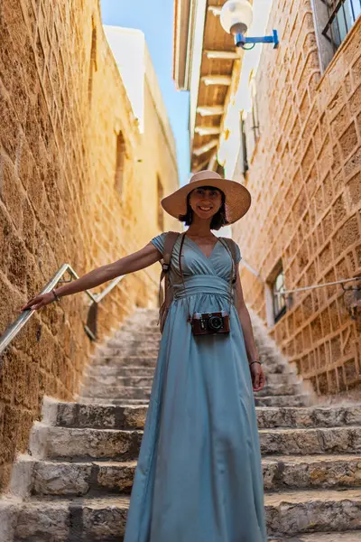 Büyüleyici görünümlü genç bir kadın eski Jaffa şehrinde güzel bir cadde boyunca yürüyor. İsrail. Seyahat ve macera.