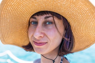 Yaz havası. Bikinili genç, sıska bir kadın denizin kenarında duruyor ve kameraya gülümsüyor. Kız yaz tatilinin tadını çıkarıyor. Kızıl Deniz 'de tatil, Eilat. İsrail.