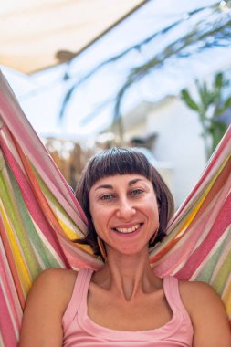 Hamakta yatan kız. Yaz tatilinin tadını çıkaran mutlu genç bir kadın. Romantik tasasız ruh hali konsepti. Yaz havası.