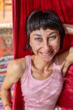 Tatilde hamakta dinlenen sakin bir genç kadın. Kız rahat bir şekilde dışarıda hamakta sallanıyor, stressiz bir hayat sürüyor. Yaz havası.