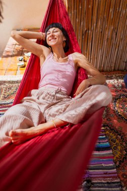 Hamakta yatan kız. Yaz tatilinin tadını çıkaran mutlu genç bir kadın. Romantik tasasız ruh hali konsepti. Yaz havası.
