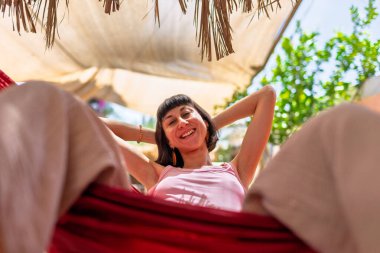 Hamakta yatan kız. Yaz tatilinin tadını çıkaran mutlu genç bir kadın. Romantik tasasız ruh hali konsepti. Yaz havası.