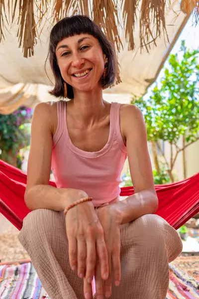 Tatilde hamakta dinlenen sakin bir genç kadın. Kız rahat bir şekilde dışarıda hamakta sallanıyor, stressiz bir hayat sürüyor. Yaz havası.