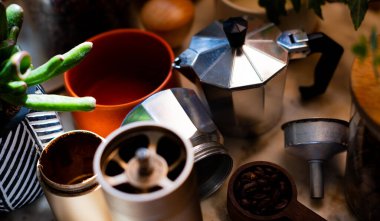 Moka kahve makinesi ve kahve makinesi mutfak masasında aksesuar yapıyor. Sıcak mutfak..