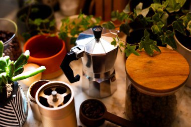 Kahve yapmak için gerekli malzemeler. Kahve makinası, kahve değirmeni ve kahve çekirdekleri rahat bir mutfağın masasında. Kahve yapmak..