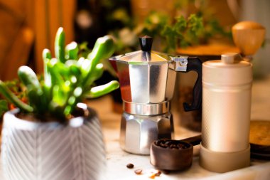 Kahve yapmak için gerekli malzemeler. Kahve makinası, kahve değirmeni ve kahve çekirdekleri rahat bir mutfağın masasında. Kahve yapmak..