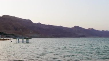 Ölü Deniz. Dağlar ve su manzarası. Otel ve deniz kıyısında bir sahil. İsrail 'de tatil. Ölü Deniz. İsrail