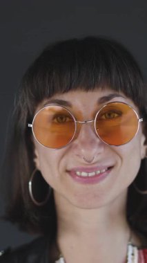 Dikey çekim. Avrupalı esmer, yakın plan portre. Havalı hippi kız piercing takıyor. Kameraya bakan kadın. Mutlu