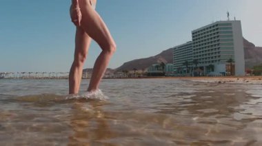 Yaz havası. Sıska kız İsrail 'de Ölü Deniz' in sahilinde dinleniyor. Tatildeki kız. Kavramsal yolculuklar ve tatiller.