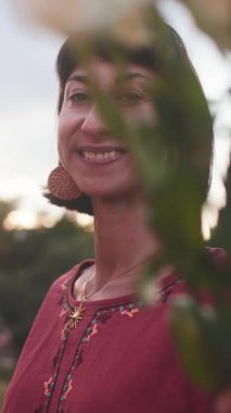 Dikey çekim. Romantik ruh hali. Gülümseyen kızlar buluşmada bir buket taze bahar çiçeği veriyorlar. Mutlu kızın yüzü çiçeklerden zevk alıyor..