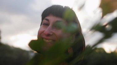 Açık havada elinde bir buket çiçekle gülümseyen kadın portresi. Kıza bir buket çiçek verilir. Genç bir bayanın yakın çekimi.