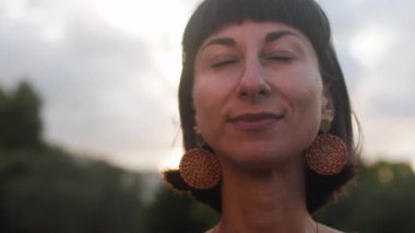 Romantik bir ruh hali. Gün batımında güzel bir elbise giymiş güzel bir kadının portresi. Kız gülümser ve kameraya bakar..