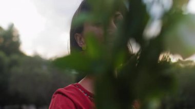 Açık havada elinde bir buket çiçekle gülümseyen kadın portresi. Kıza bir buket çiçek verilir. Genç bir bayanın yakın çekimi.