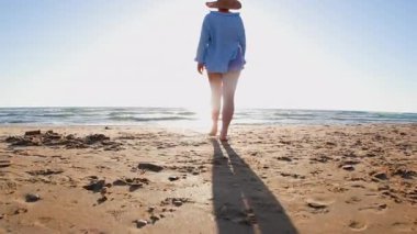 Kumsalda yürüyen mutlu ve boyunda bir kız. Vücut pozitif. Sahildeki kız. Yaz havası.