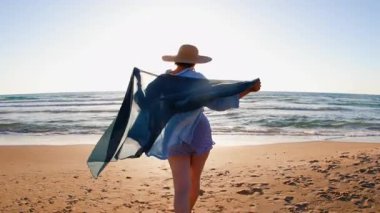 Gün batımında kumlu sahilde yürüyen ve vücut pozitifliğinin tadını çıkaran mutlu artı beden kız. Sahildeki kız. Yaz havası.