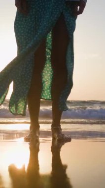 Dikey çekim. Genç ve zayıf kadın sahilde huzurlu bir gün batımının tadını çıkarırken hayat yolculuğunu yansıtıyor. Romantik