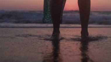 Zayıf kadın sahilde huzurlu bir gün batımının tadını çıkarırken hayat yolculuğunu yansıtıyor. Romantik atmosfer. Yaz havası. Yürümek.