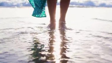 Zayıf kadın sahilde huzurlu bir gün batımının tadını çıkarırken hayat yolculuğunu yansıtıyor. Romantik atmosfer. Yaz havası. Yürümek.