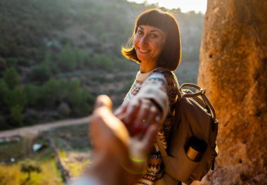 Beni takip edin. Mutlu çift seyahat ediyor. Dağlardaki mutlu kadın turistin portresi. Kız gülümsüyor. Yürüyüş ve yürüyüş. Spor ve sağlıklı yaşam tarzı konsepti. Sırt çantalı kız.