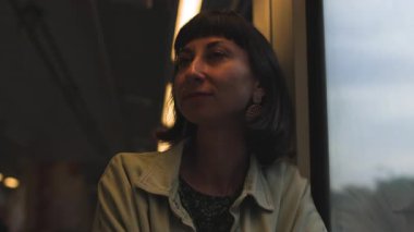 Tren yolculuğu sırasında pencereden dışarı bakan genç bir kadın. Tren penceresinden dışarı bakan bir turist. Nostaljik kadın evini özlüyor ve...