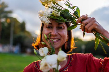 Gün ışığında bir buket taze bahar çiçeğiyle gülümseyen kadın yüzünü kapat. Çiçek tomurcuklarından hoşlanan mutlu kızın yüzü. Romantik ruh hali. Çiçek buketli kadın.