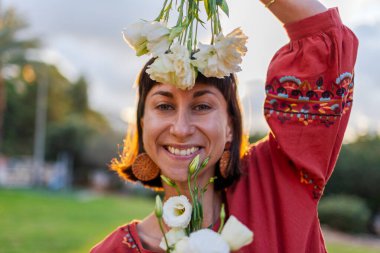Açık havada elinde bir buket çiçekle gülümseyen kadın portresi. Kıza bir buket çiçek verilir. Bir yaz akşamı romantik bir ruh hali olan genç bir kadının yakın çekimi..