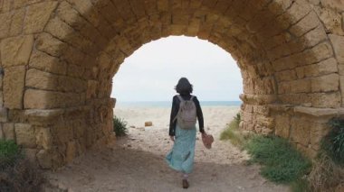 İsrail 'de seyahat eden bir kız su kemerinin etrafında yürüyor. Seyahat ve macera. Bir kız yazın seyahat eder..