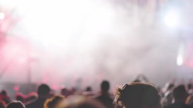 Seyirciler kollarını kaldırmış, yanıp sönen ışıklar ve güçlü bir atmosferi olan enerjik bir kaya gösterisinin keyfini çıkarıyorlar. Kalabalık canlı müzikten hoşlanıyor.