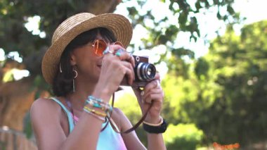 Sokakta kamerası olan çekici bir kadın. Sokakta gülümseyen güzel bir kızın portresi. Film kamerası olan şık bir turist.