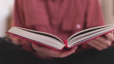 Elinde kitap olan bir kadın. Kız kitabı kapatıyor. Okumaktan zevk alıyorum. Kız okuyor..