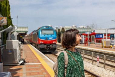 Tren istasyonunda durmuş treni bekleyen kız. Sırt çantalı kadın treni bekliyor. özgürlük ve seyahat kavramı.